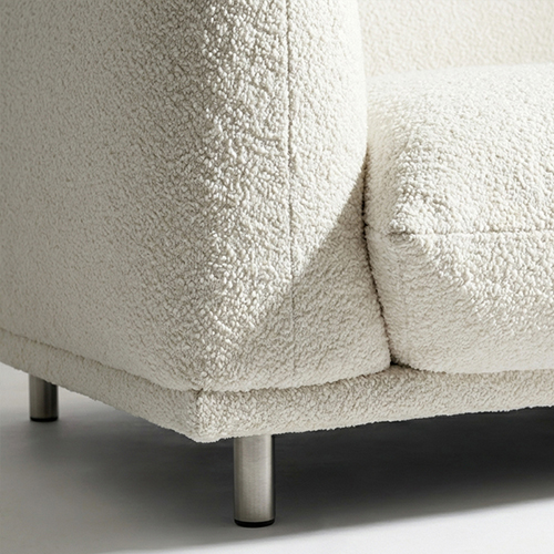 Close-up of a boucle sofa cushion and metal leg